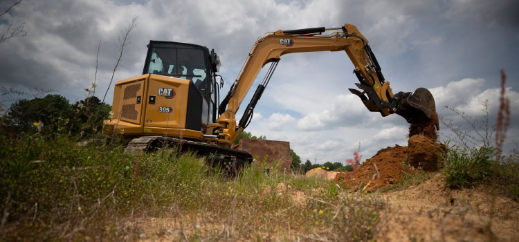 An image of a Caterpillar back hoe outside.