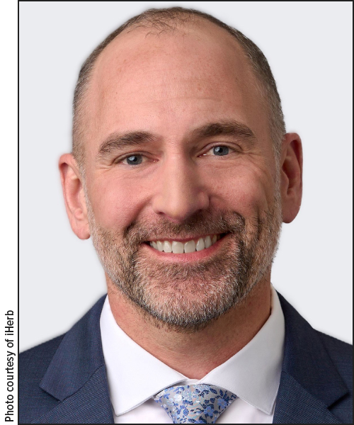 Foto de cabeza de Zach Thomann, director de operaciones de iHerb.