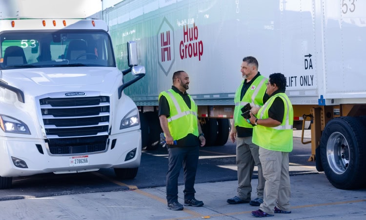 Group of workers near Hub Group trucks.