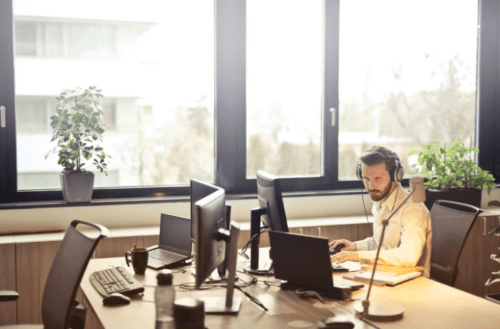 person working at desk with two screens