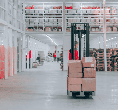 warehouse employee moving boxes on forklift