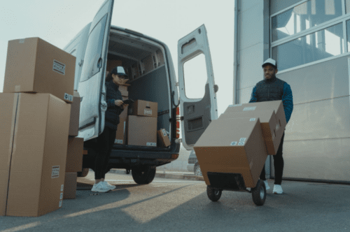 worker pushing boxes on dolly